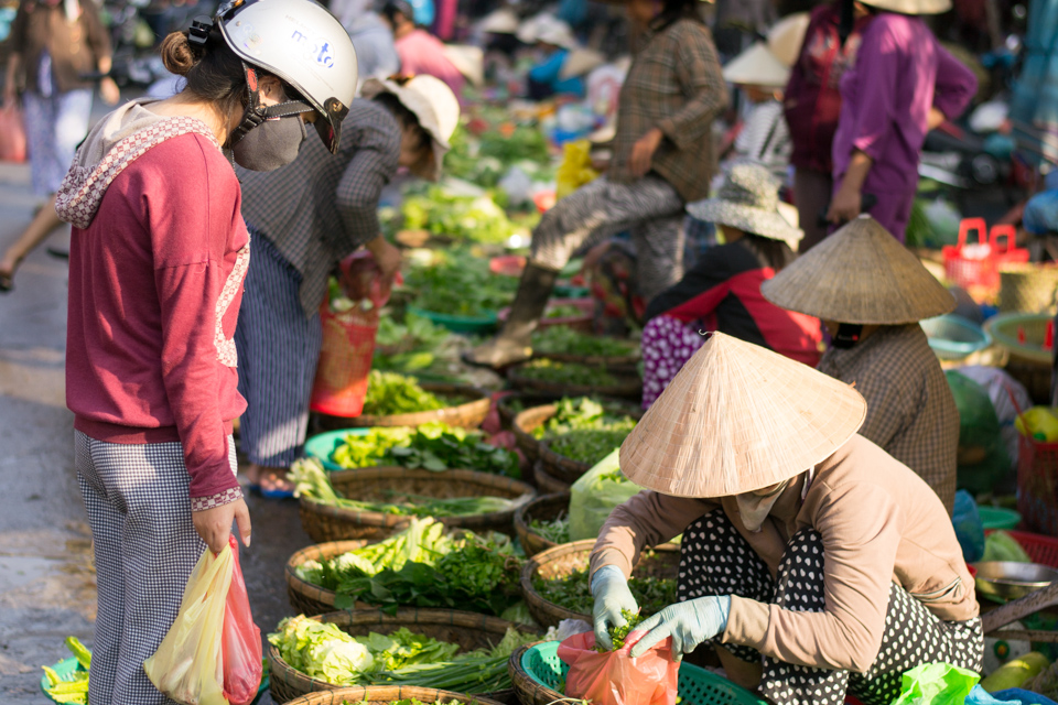 Woman buying fresh vegetables from Hoi An Central market