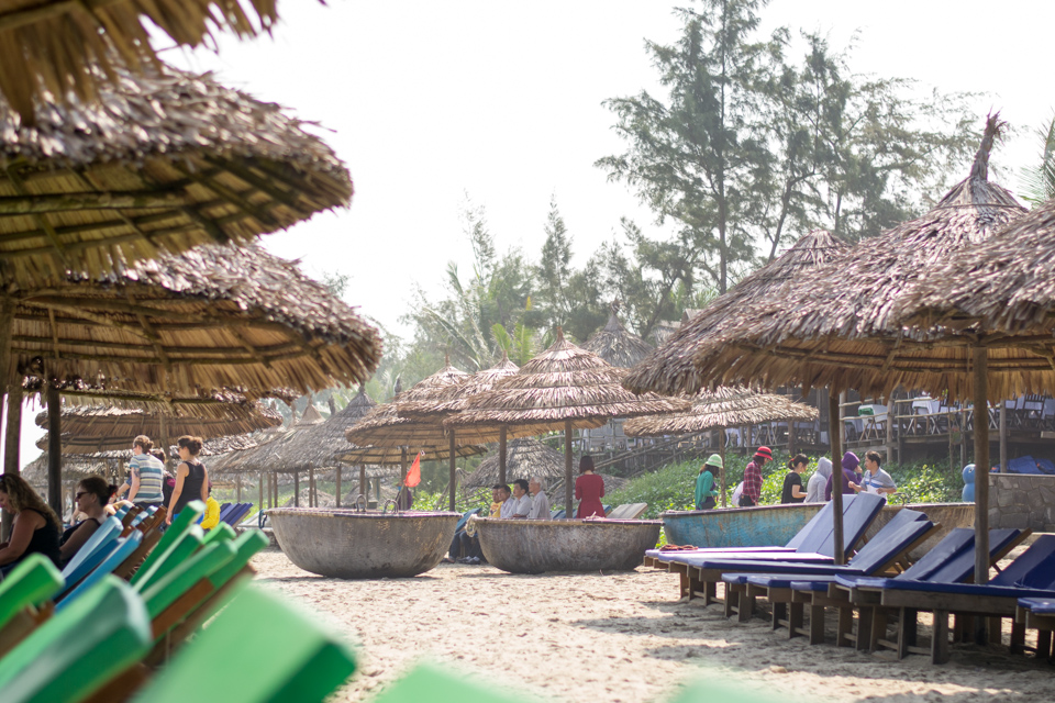 Bamboo basket boats and lounge chairs under thatched umbrellas 