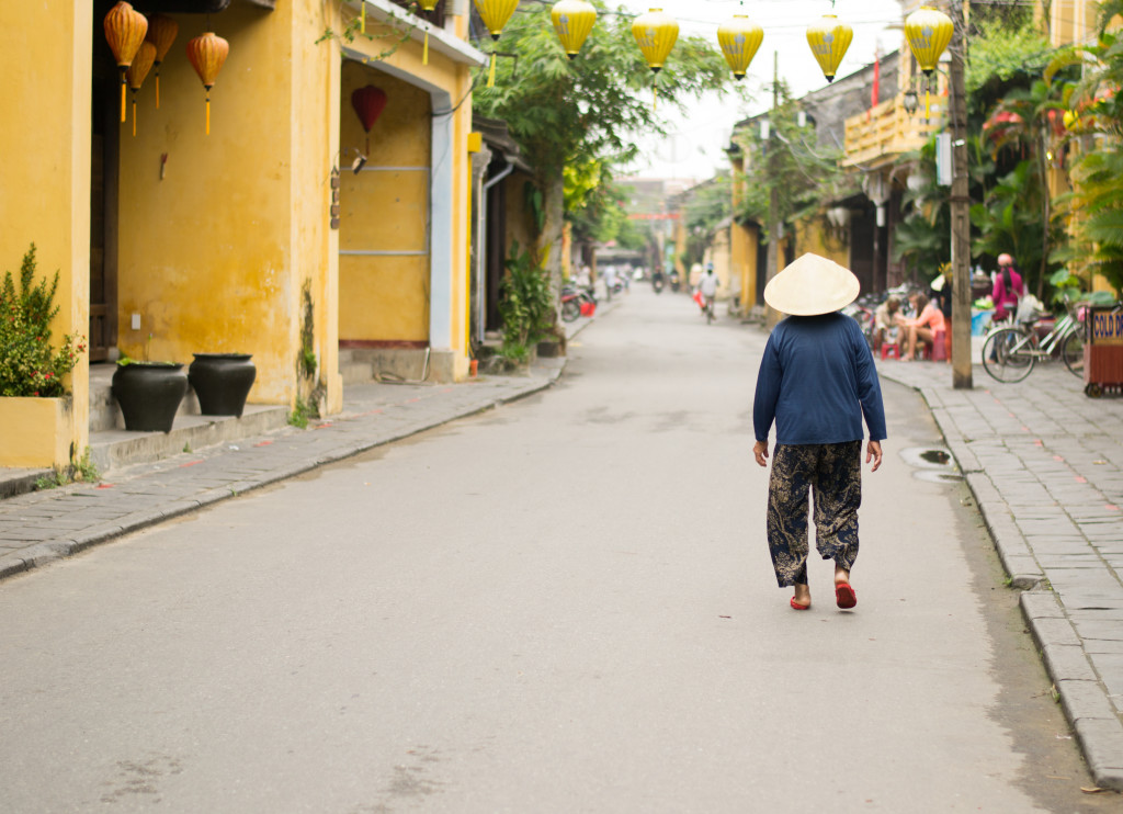 Lady in cone hat walking down the street in Vietnam