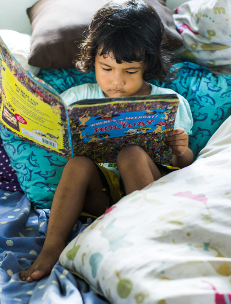 A young boy from the Bali Life Foundation reading a book