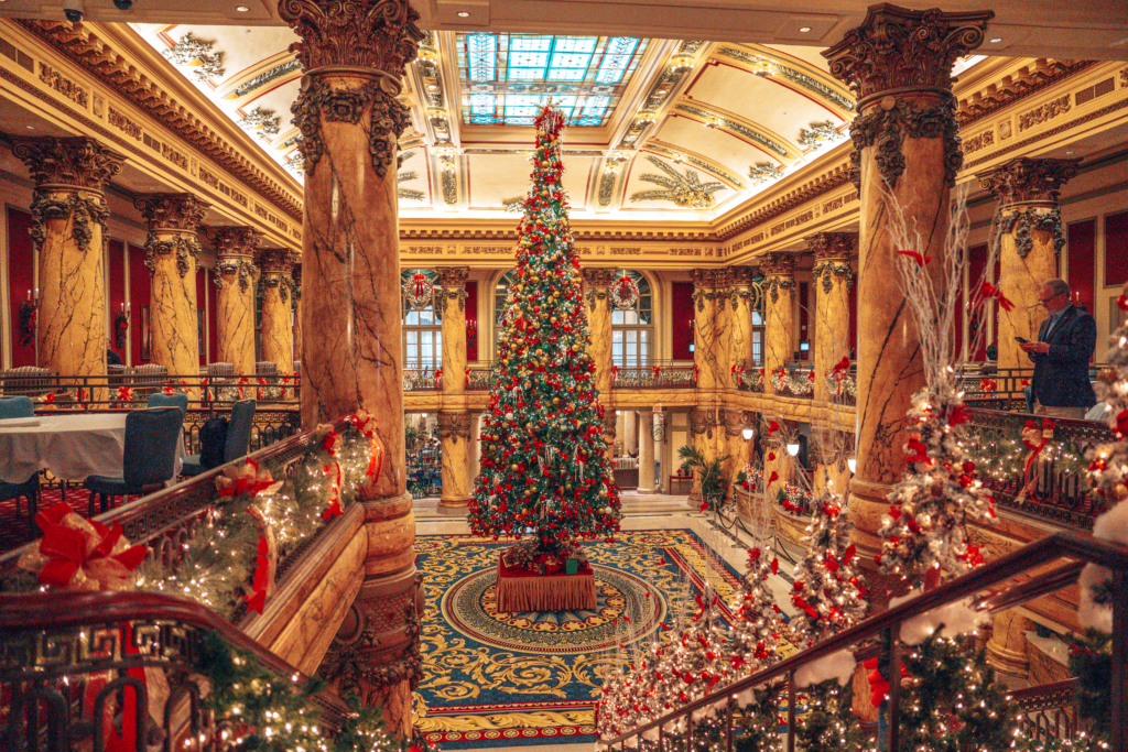 Elegant grand staircase with large christmas tree, decorated in red and green colors and lights for the holidays at The Jefferson Hotel in Richmond, Virginia